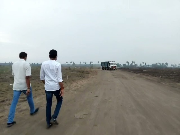 Minister Kodali Nani filling the clay layout from the tipper